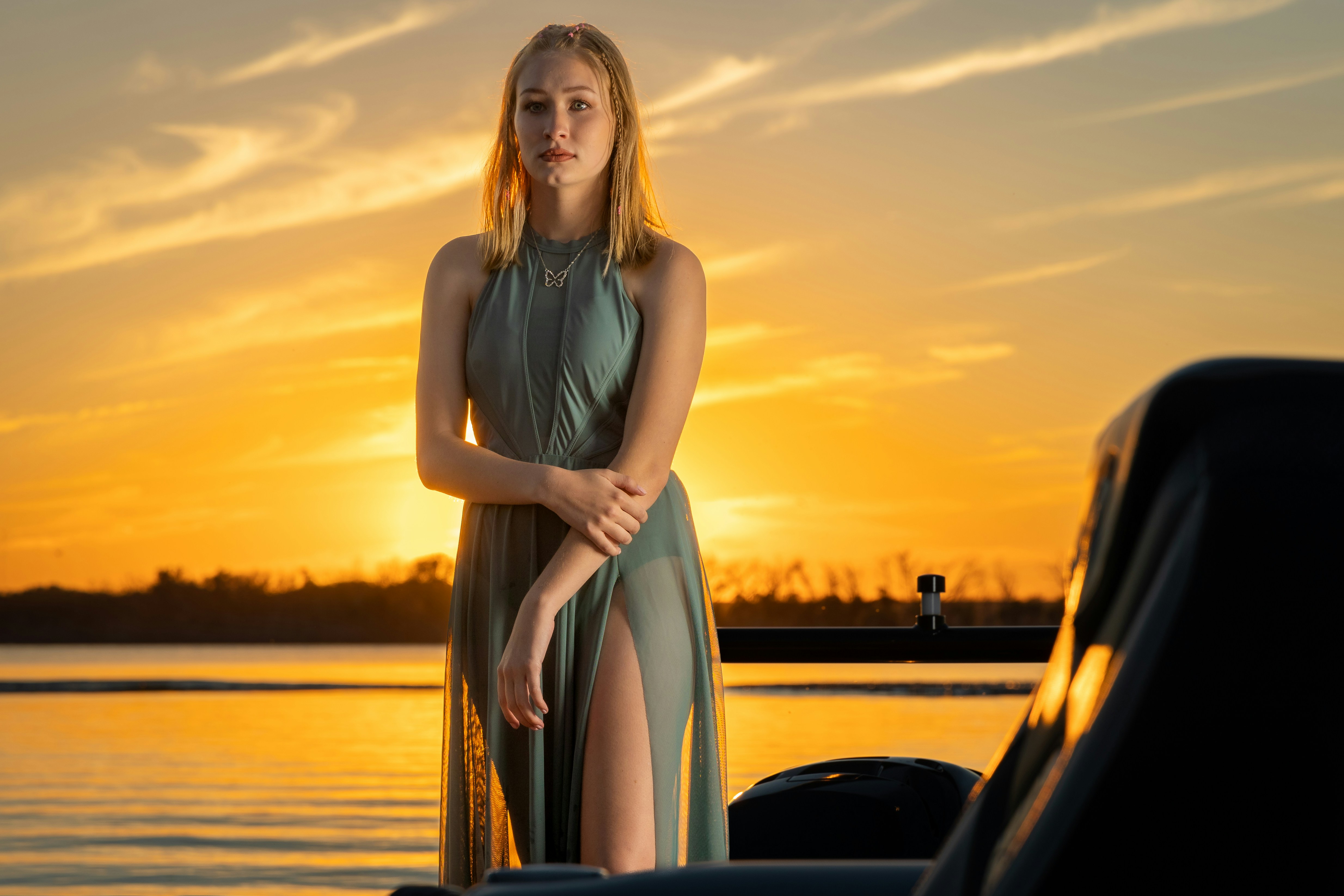 a woman in a dress standing by a car