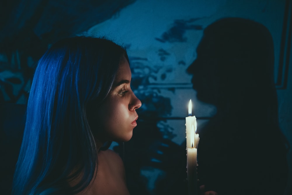 a woman looking at a candle