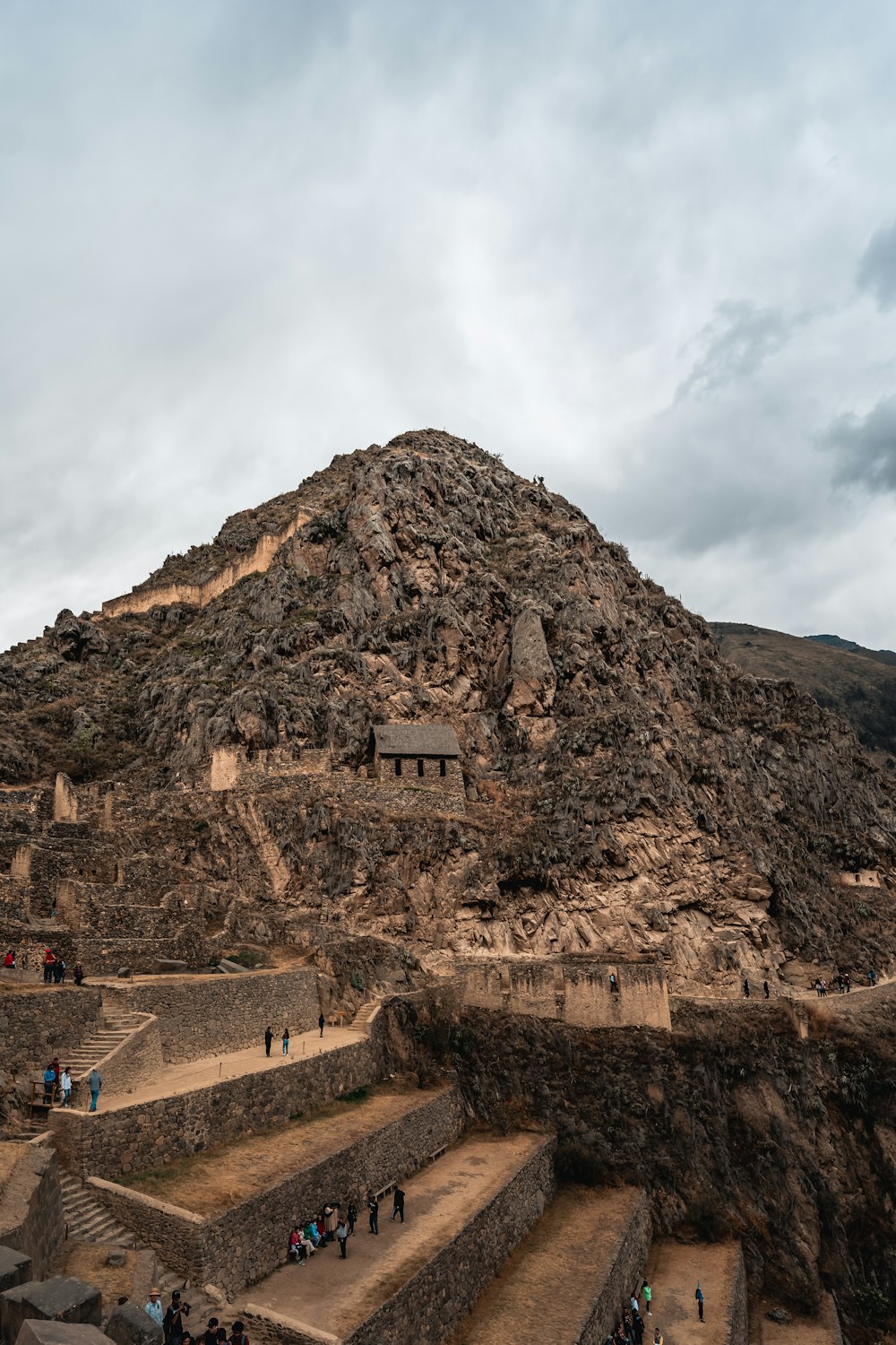 a large rock cliff with people walking up it