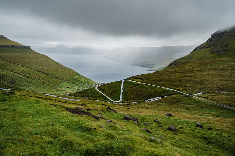 a road going through a valley with Winnats Pass in the background