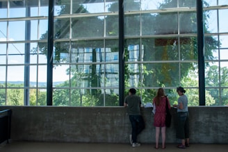 A real estate agent showing a house to potential buyers in a bright living room.