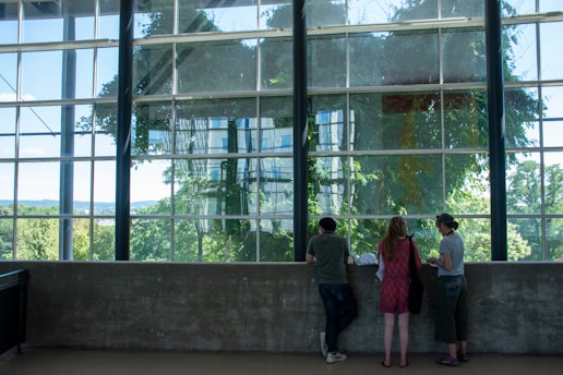 A real estate agent showing a house to potential buyers in a bright living room.