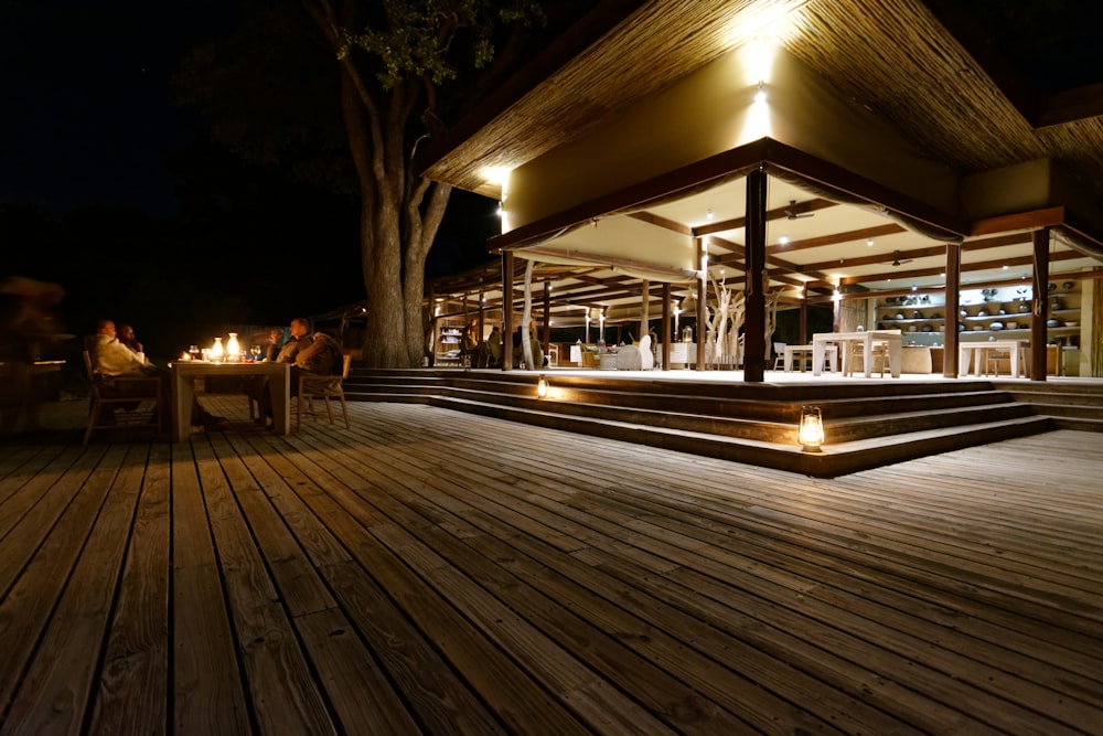 a wood deck with a tree and a building in the background