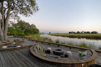 a wooden deck with a pond and trees