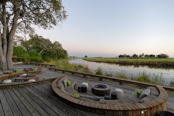 a wooden deck with a pond and trees