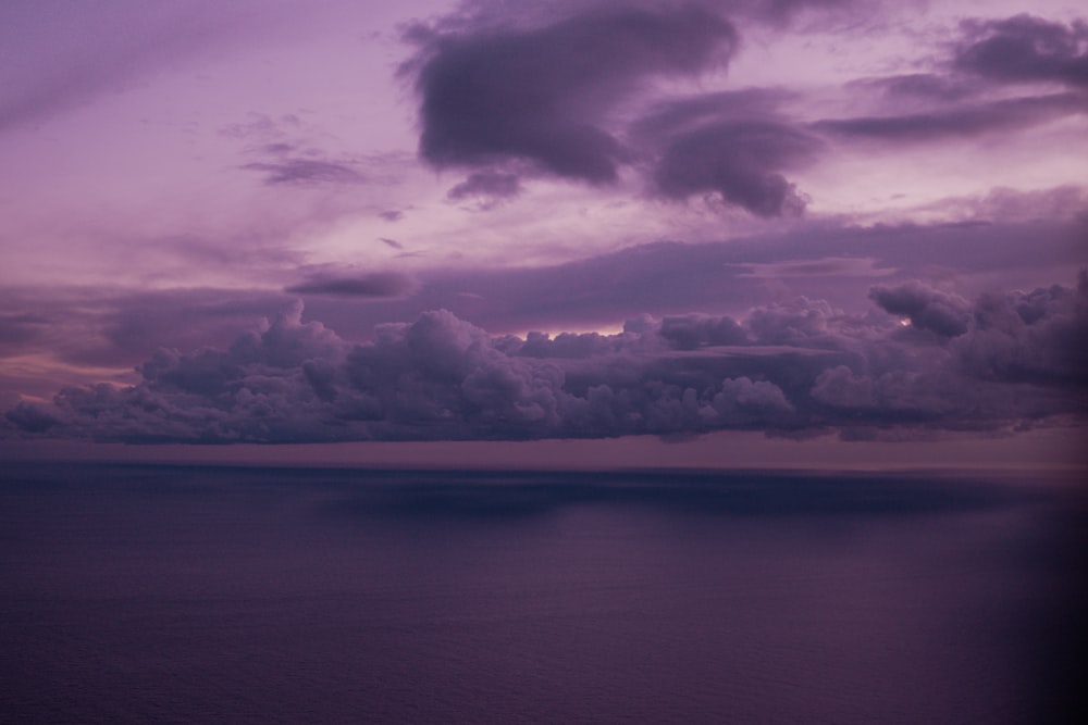 a body of water with clouds above it