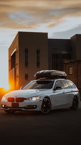 A happy family loading a roof box onto their car before a holiday trip.