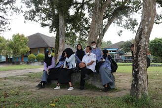 A group discussion outdoors under trees during a study retreat.