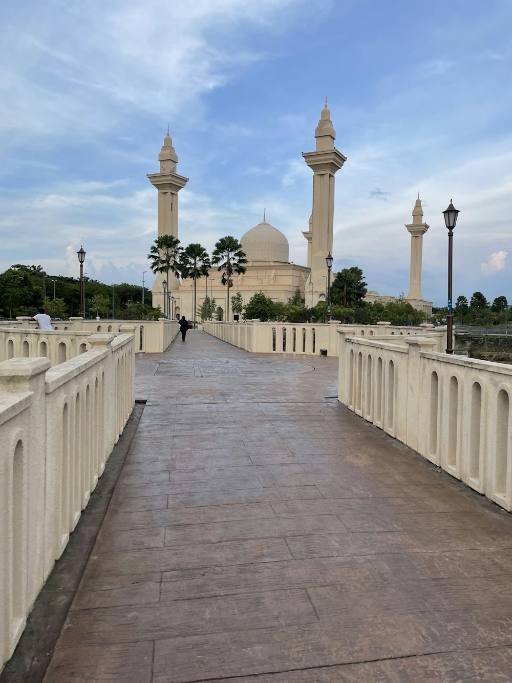 a walkway with a white building in the background