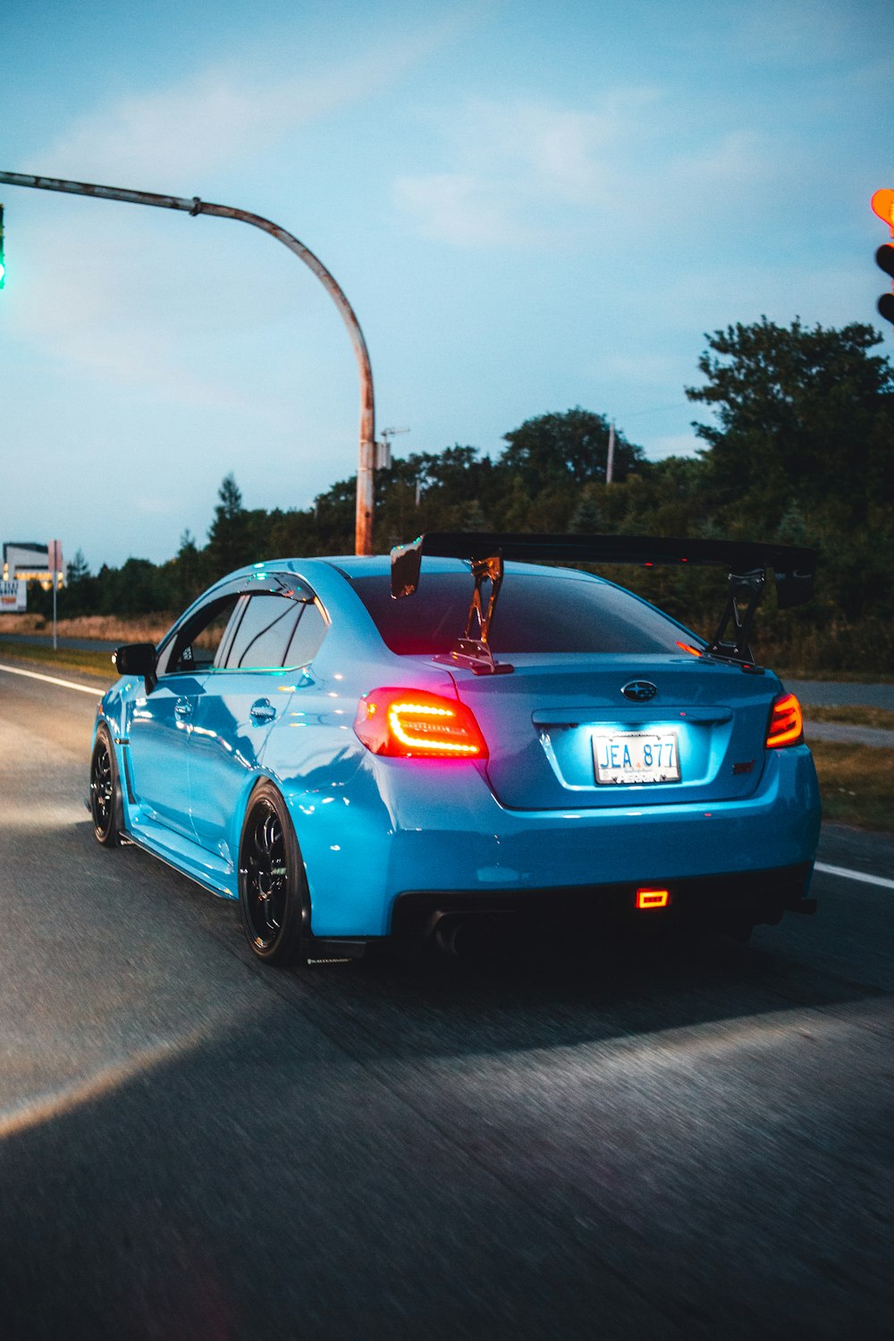 a blue sports car on a road