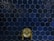 A wall covered with dark blue hexagonal tiles, featuring a central antique brass faucet with intricate handles.