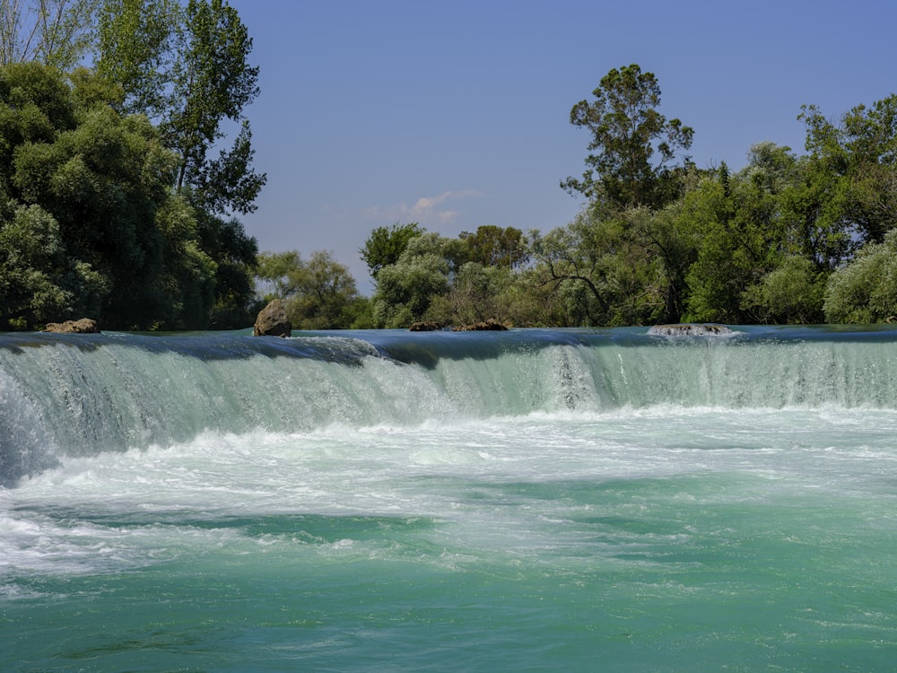 a waterfall with trees in the background