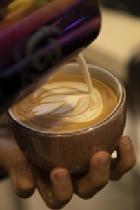 A steaming cup of specialty coffee with latte art in a sleek ceramic cup.