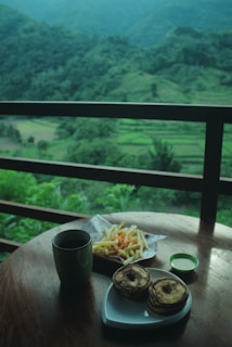 Guests enjoying a sunny breakfast on a homestay balcony overlooking rolling hills.