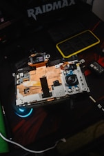 Close-up of a technician repairing a sleek black laptop inside a modern shop.