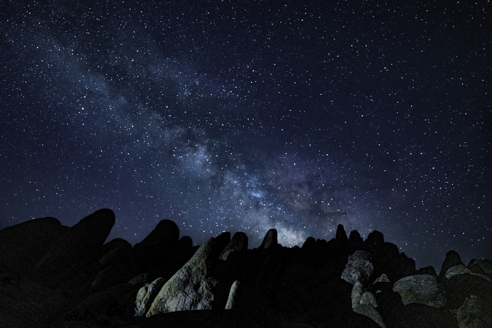 a rocky mountain with a starry sky above