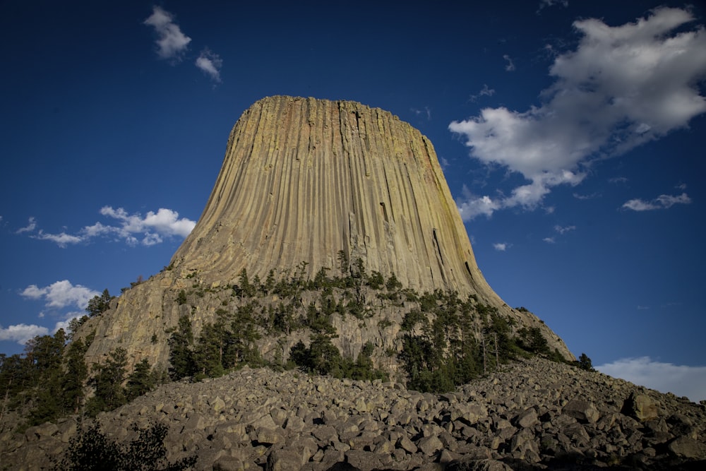 a large rock formation with Devils Tower in the background