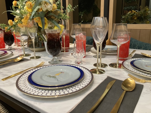 Elegant tableware set on a dining table with polished cutlery and glassware.