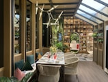 An elegant dining table set in a bright room with plants.