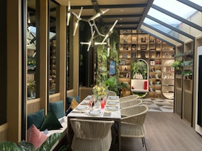 An elegant dining table set in a bright room with plants.