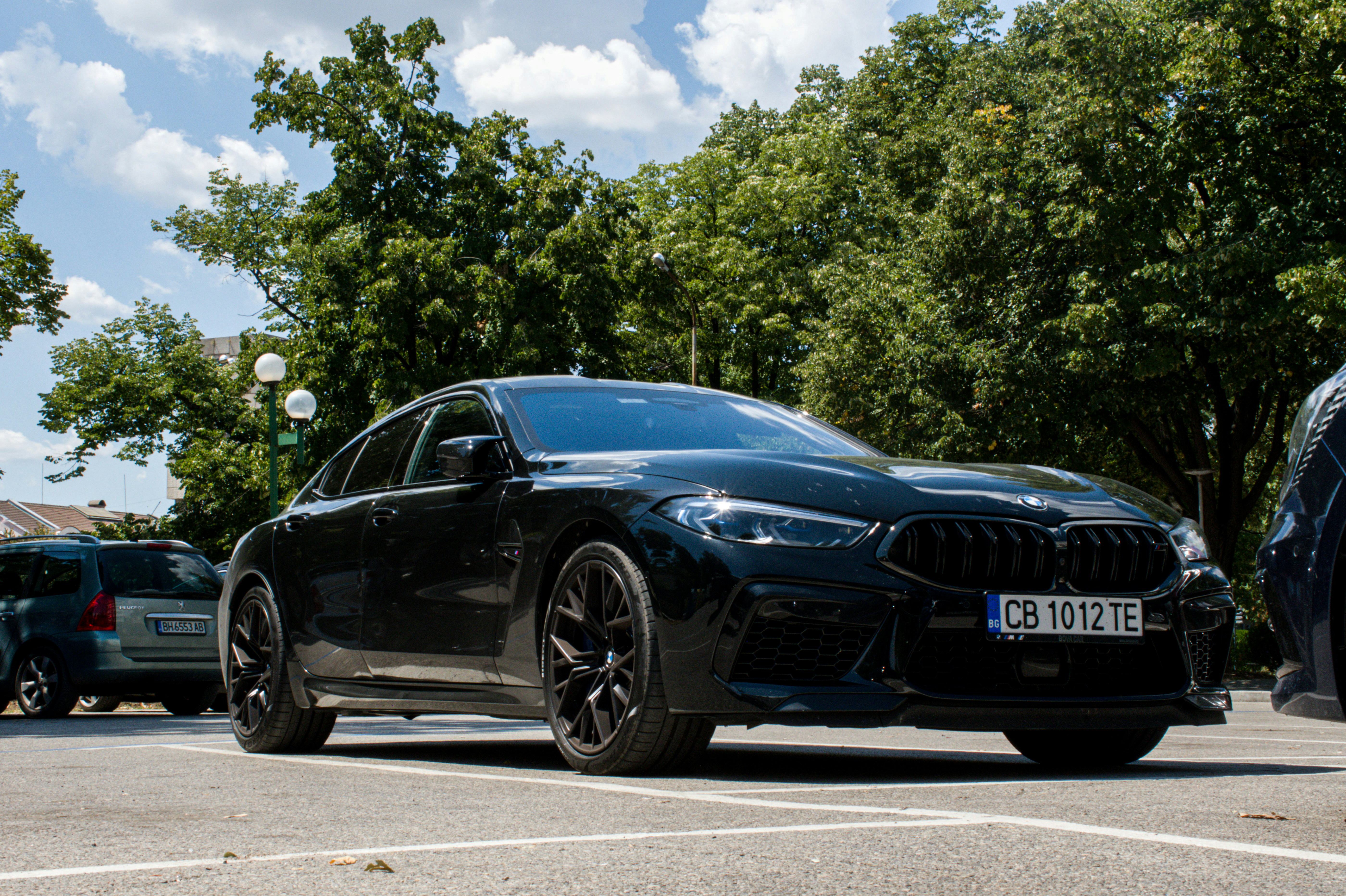 Grey BMW M8 Gran Coupe parked in modern urban setting at twilight