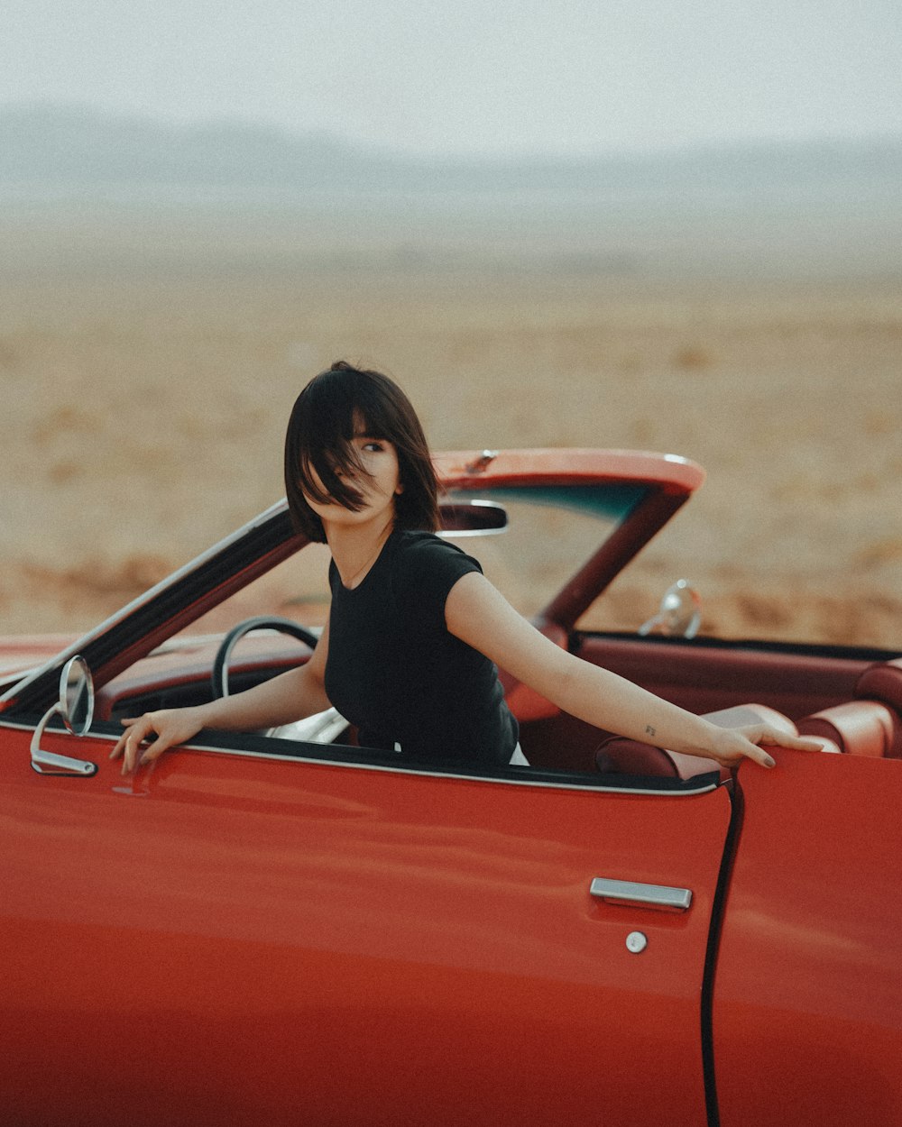 a person sitting in a convertible car