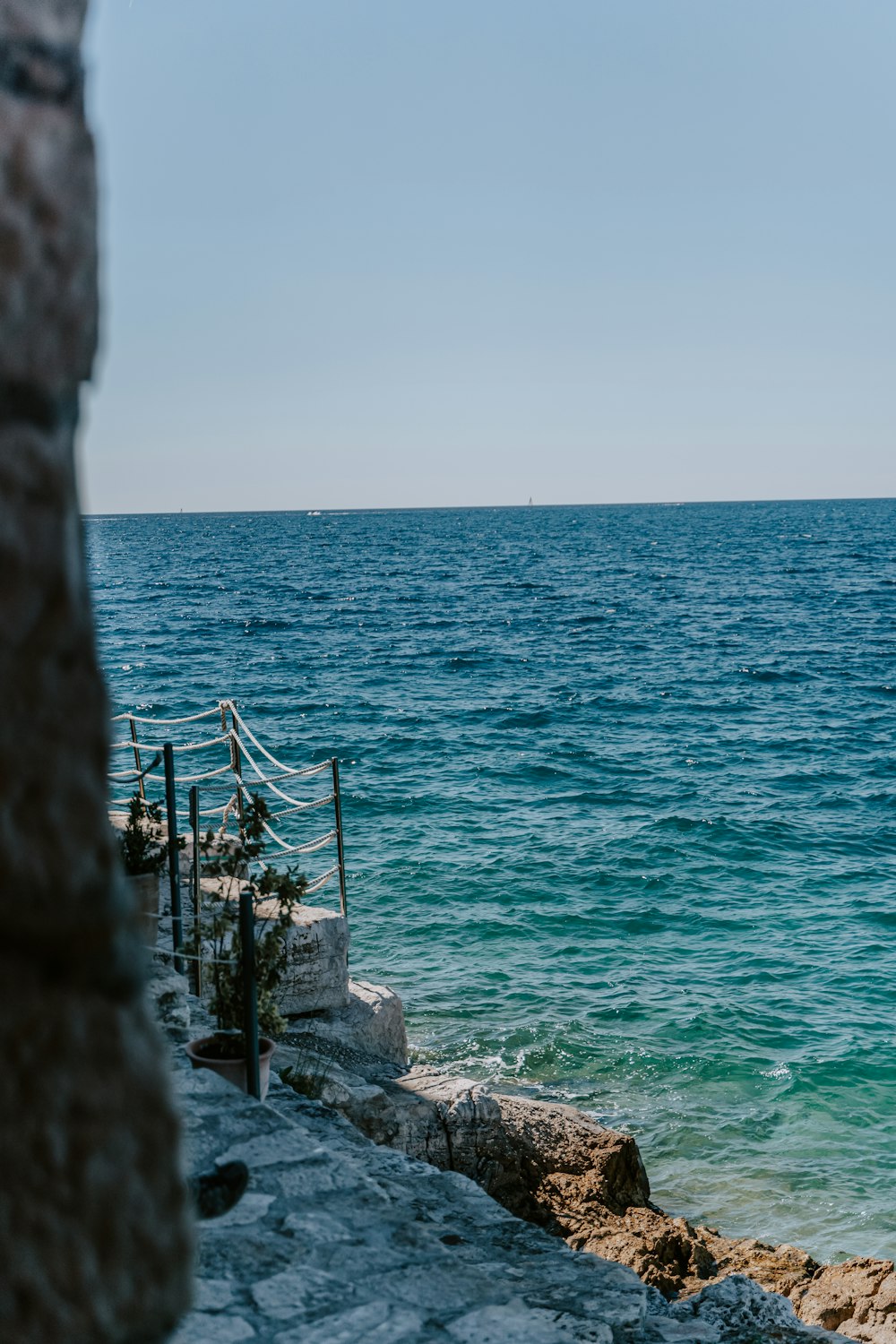 a rocky beach with a body of water in the background