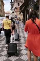 A group of travelers stepping off the bus at a historic city square.