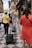 Smiling travelers exploring a vibrant city street with luggage.