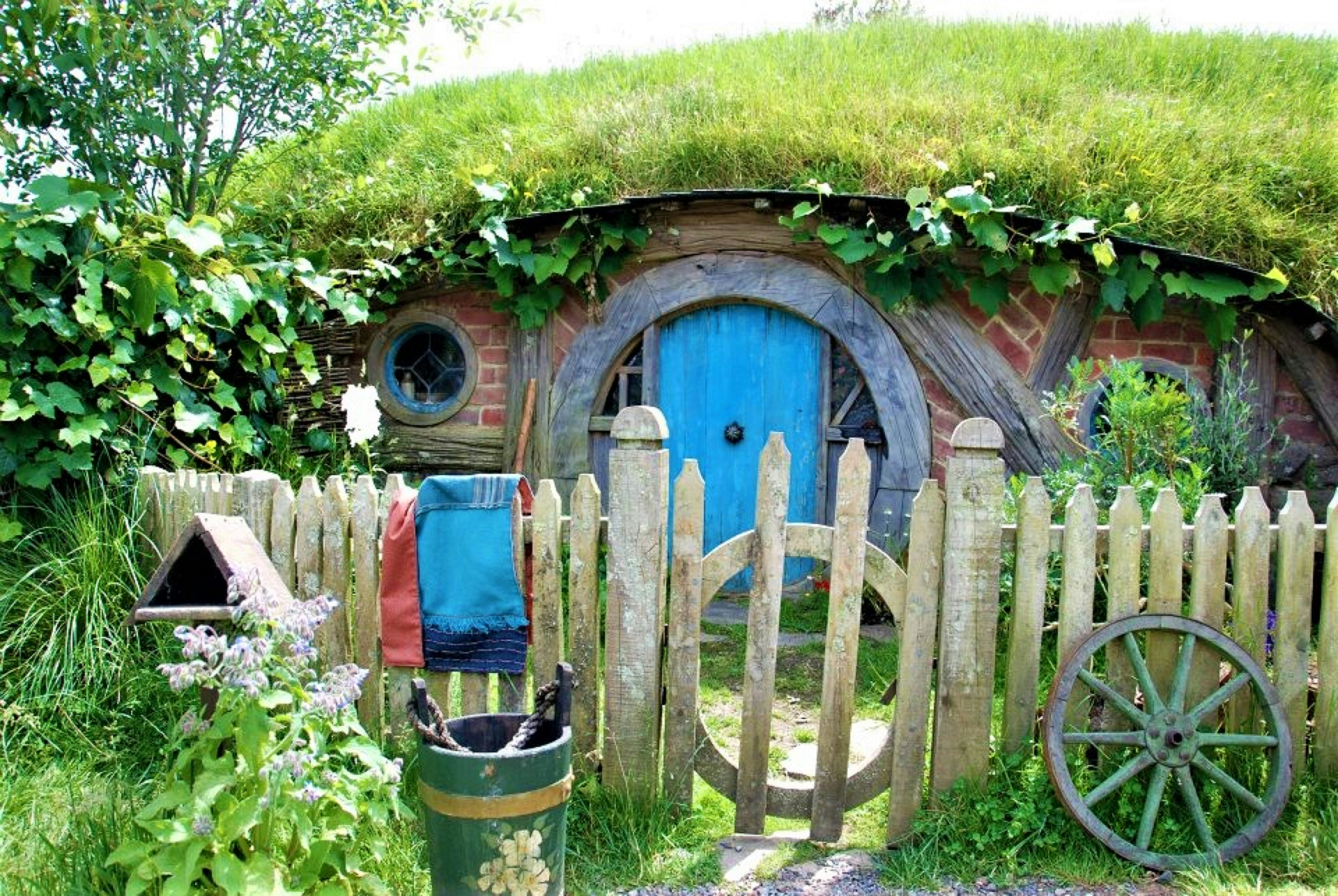 a wooden fence with a wheelbarrow and a wheelbarrow, If you use my photos please consider making a small donation here https://www.buymeacoffee.com/KerinGedge :) And of course, a collection of Hobbiton related pictures wouldn