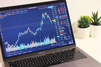 Modern trading desk with multiple screens showing forex and CFD charts.