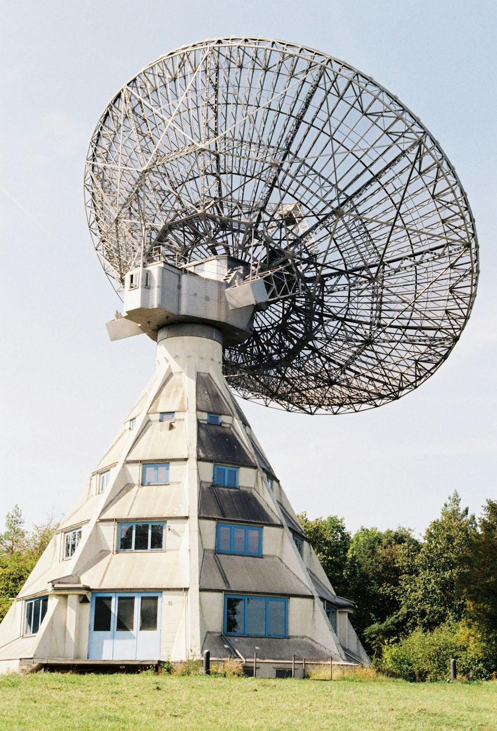 大きな白い建物の上に大きな衛星放送受信アンテナ