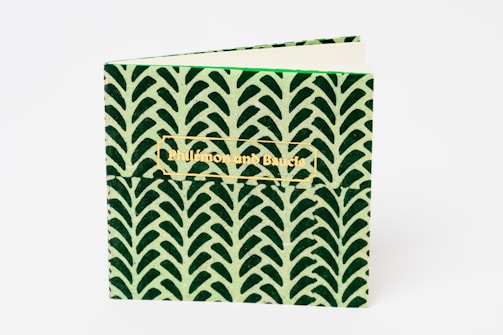 A small, square-shaped notebook with a green and black leaf pattern on the cover. The title 'Philemon and Baucis' is embossed in gold text on the front.