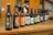 A close-up of a variety of beverage bottles on a wooden table.