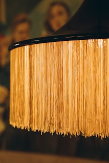 Close-up of a craftsman applying special adhesive to a lampshade frame.