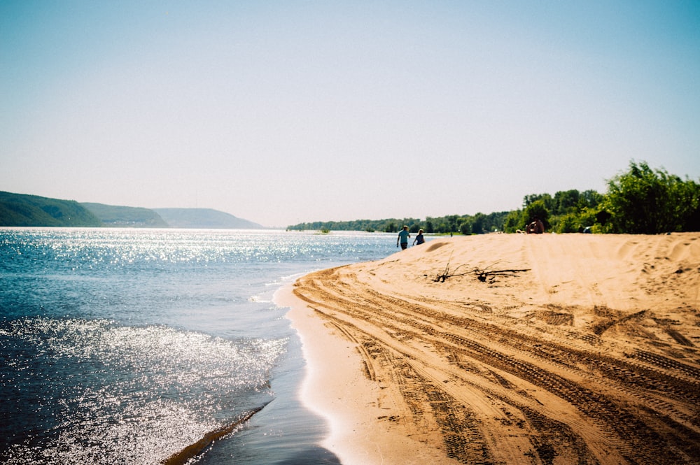 a beach with people walking on it