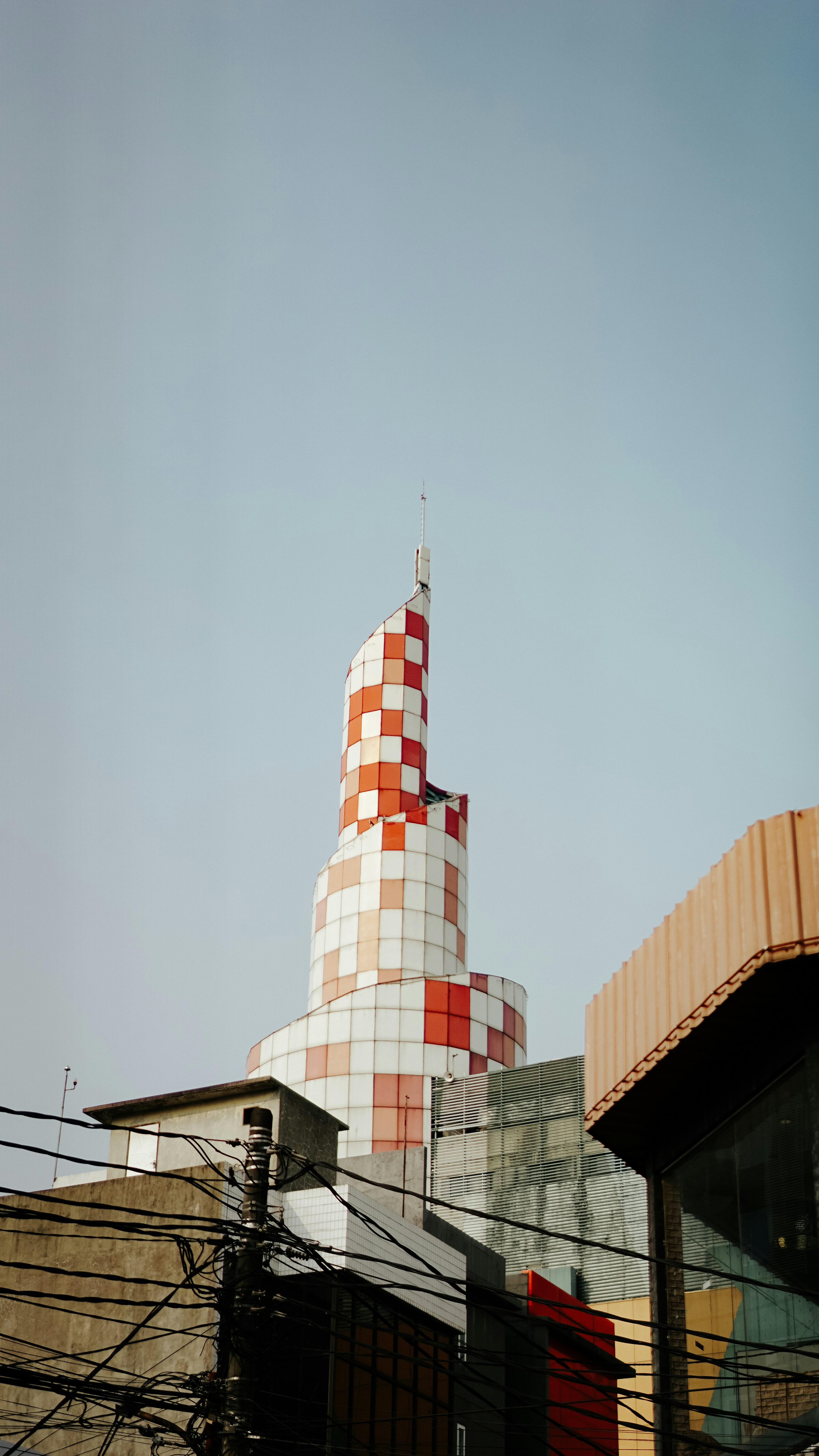 a tall building with a red and white tower
