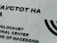 A portion of a building wall featuring black text in both Cyrillic and English. The text reads 'Holocaust Memorial Center for the Jews of Macedonia.' The wall is light gray and textured, and there is a partial image of a Menorah symbol to the right.
