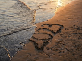 a beach with a heart drawn in the sand