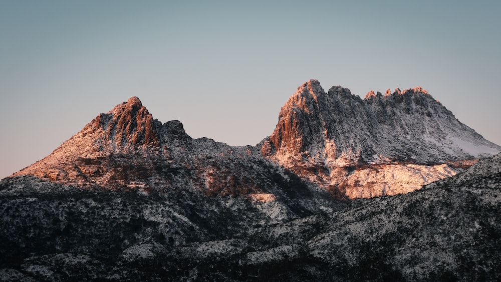 a rocky mountain with a blue sky