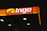 A brightly illuminated gas station canopy at night with the logo 'ingo' displayed prominently in white and a partially yellow background on an orange panel.