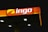 A brightly illuminated gas station canopy at night with the logo 'ingo' displayed prominently in white and a partially yellow background on an orange panel.