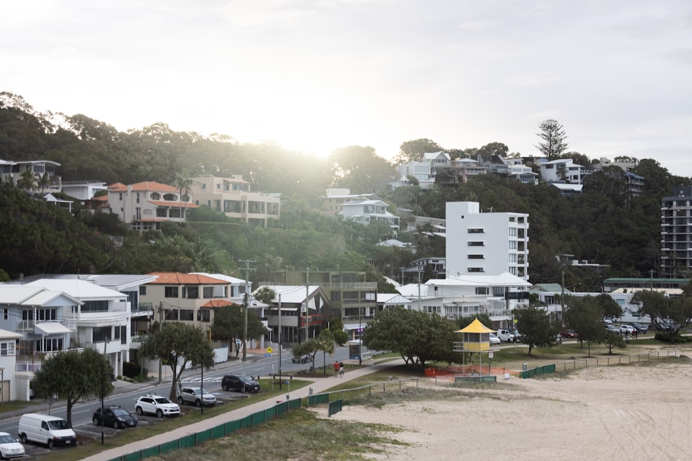 a group of buildings with trees and cars in front of them