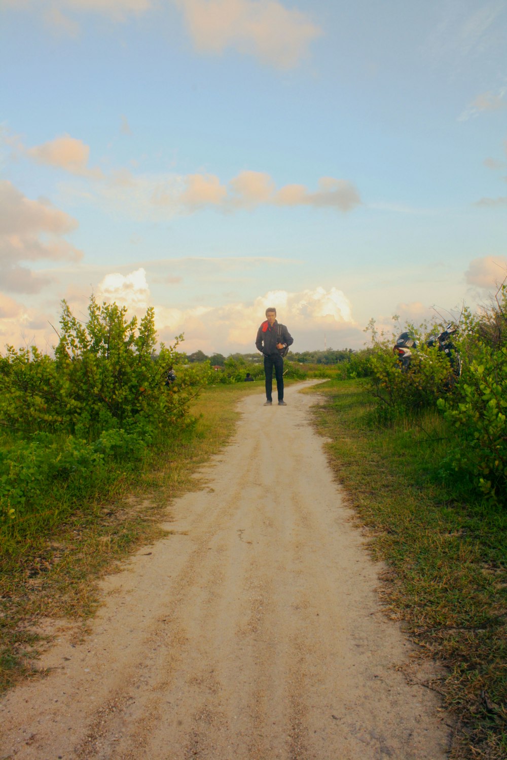 a man standing on a dirt road