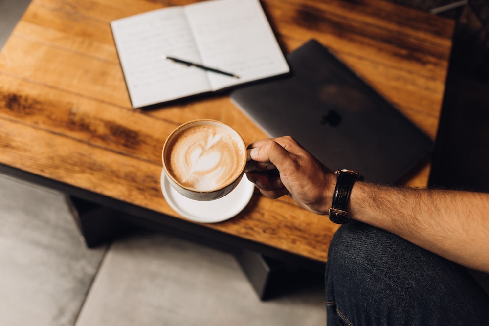 a person holding a cup of coffee