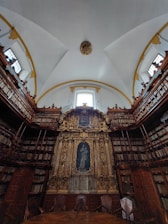 A warmly lit seminary library with rows of ancient theological books and a wooden pulpit bathed in soft light.