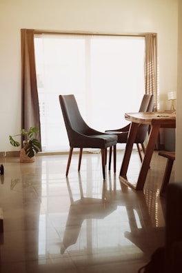 A modern dining table set with sleek chairs in a bright, airy room.