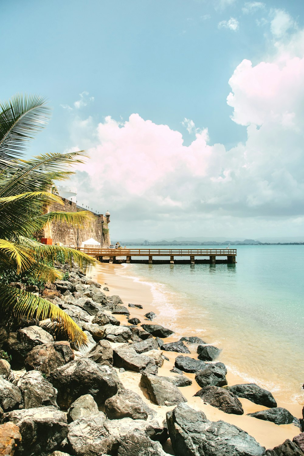 a rocky beach with a pier and a body of water