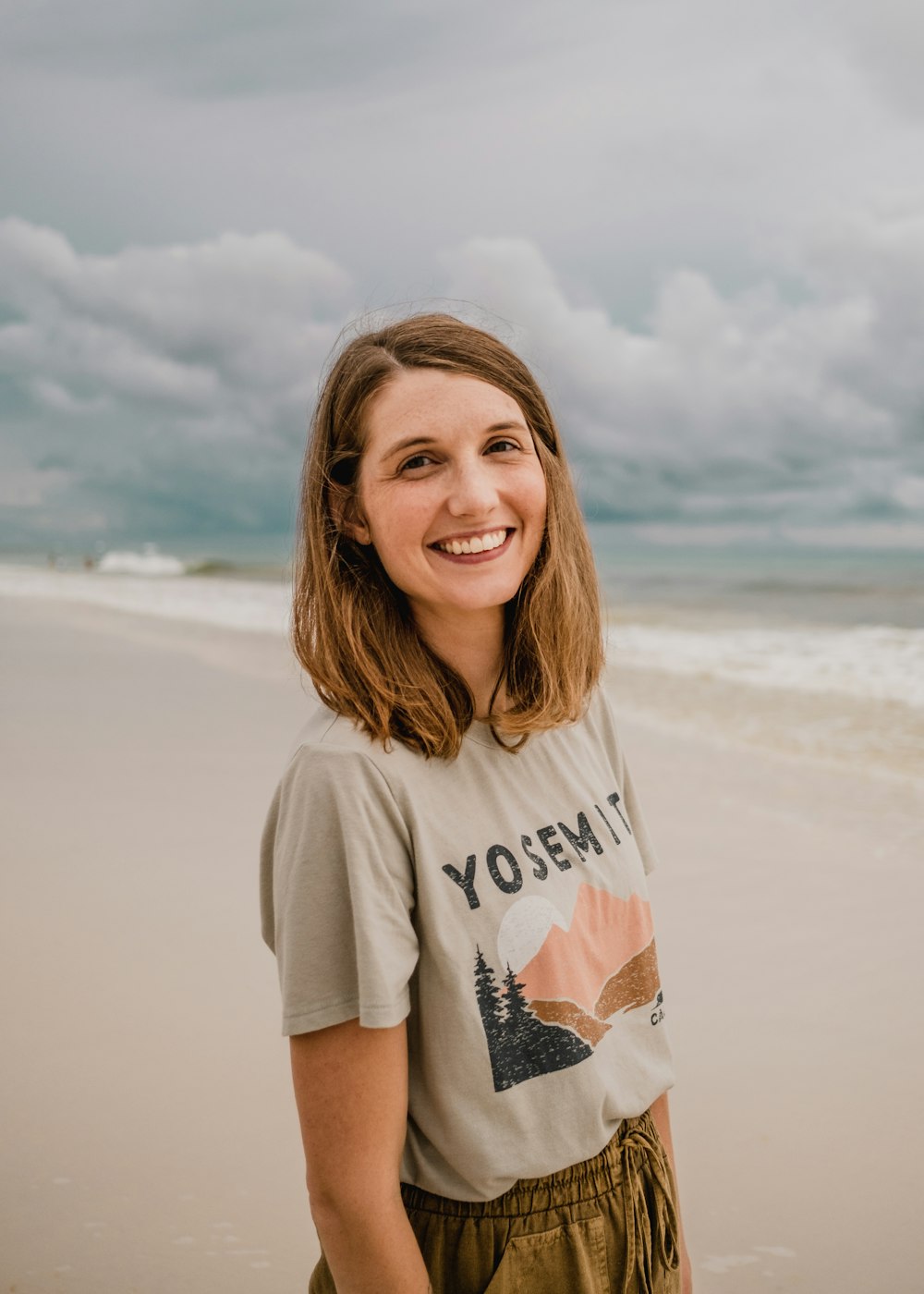 Eine Person, die an einem Strand steht und für die Kamera posiert