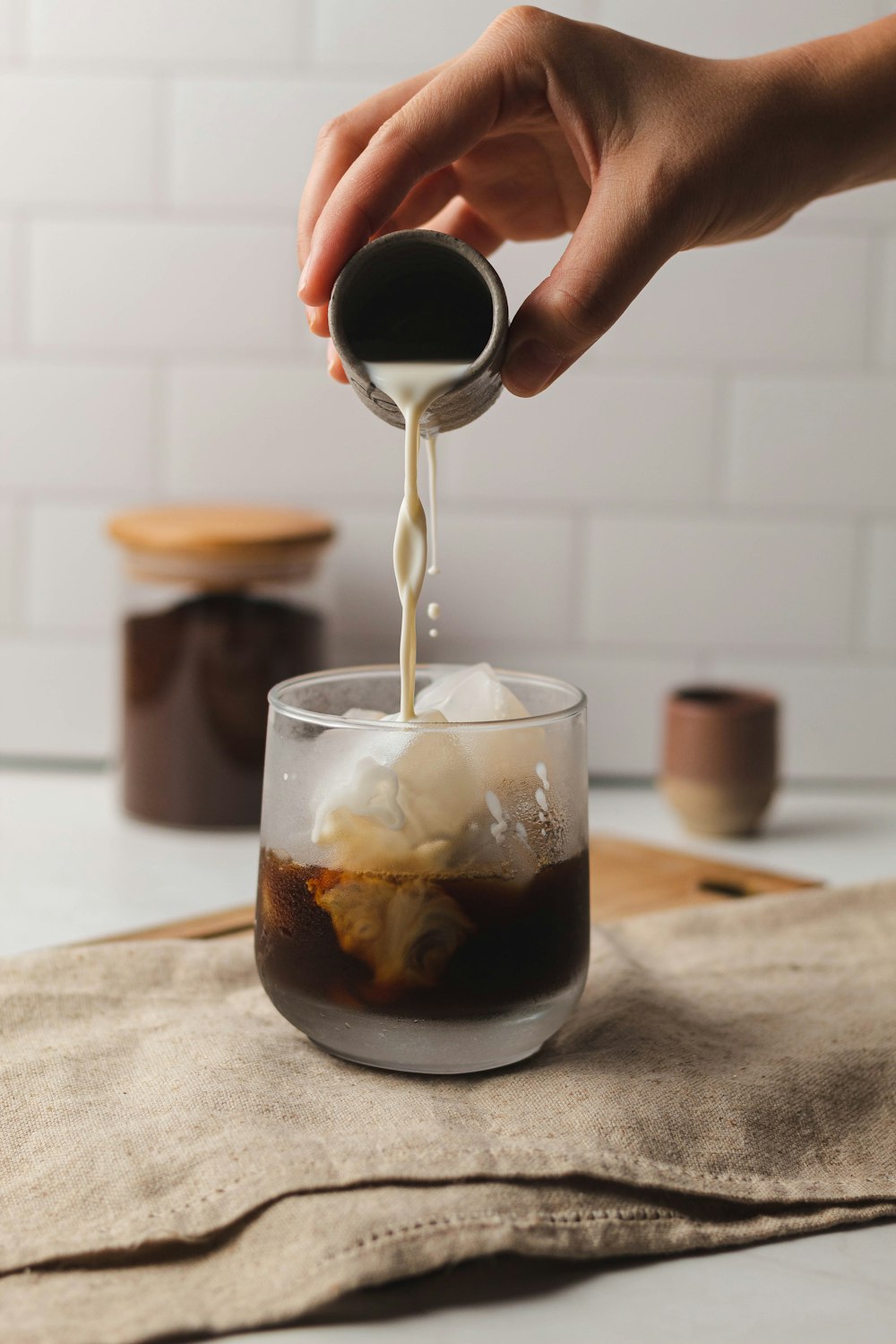 a hand pouring a drink into a glass